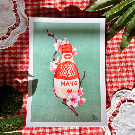 Framed artwork of a mayonnaise bottle with cherry blossoms on a red and white checkered tablecloth.